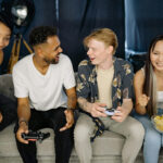 テレビゲームをしている人種の入り混じった若者たち