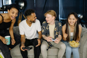 テレビゲームをしている人種の入り混じった若者たち